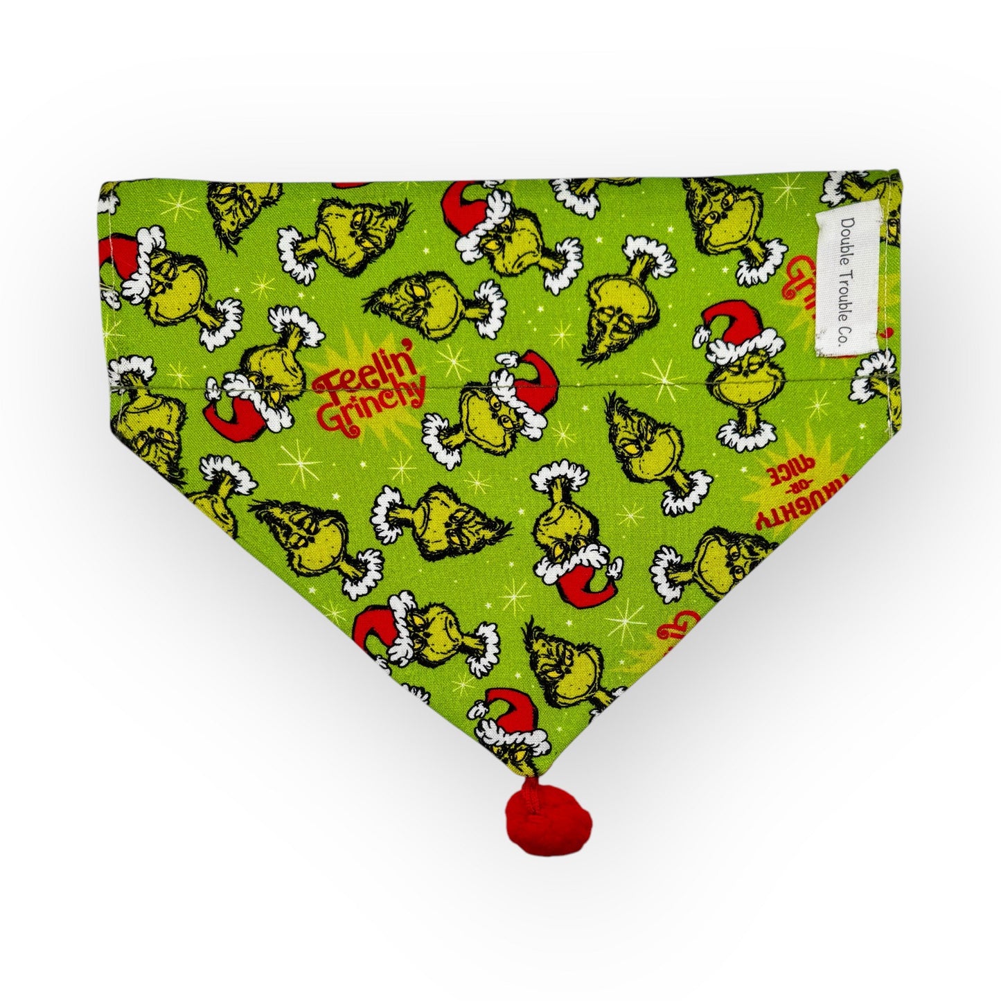 A green bandana with a Christmas themed pattern featuring the grinch in a Santa hat.